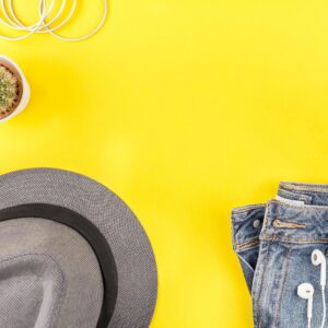 Taupe cropped denim jacket flat lay on soft sand background
